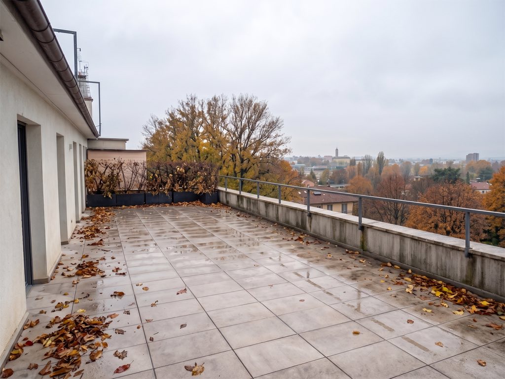 Prima: terrazzo spoglio in autunno, con cielo grigio e foglie a terra.